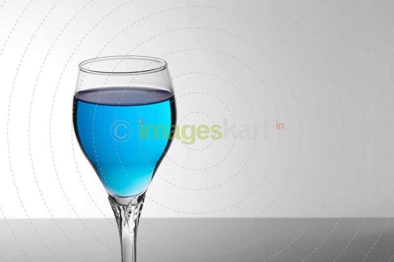 a glass of blue mocktail against white background 