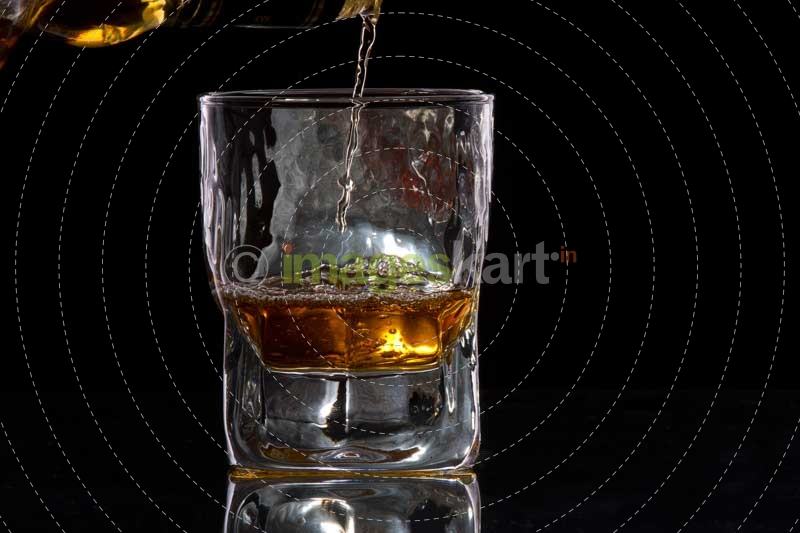 whiskey pouring from a bottle into a glass
