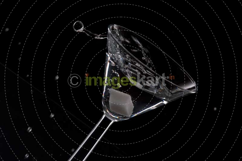 a glass of martini in motion against dark background 