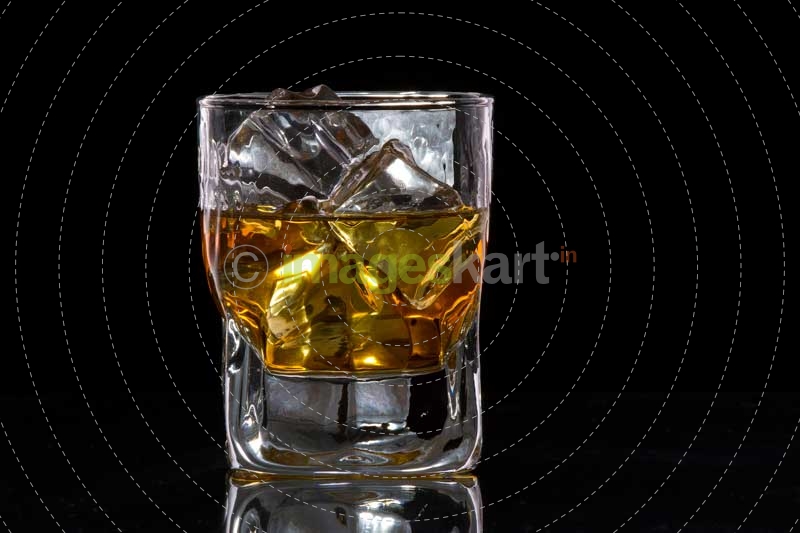 a glass of scotch with ice cubes