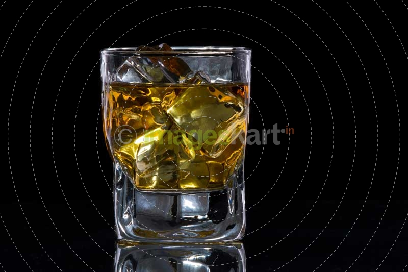 a glass of alcohol with ice cubes