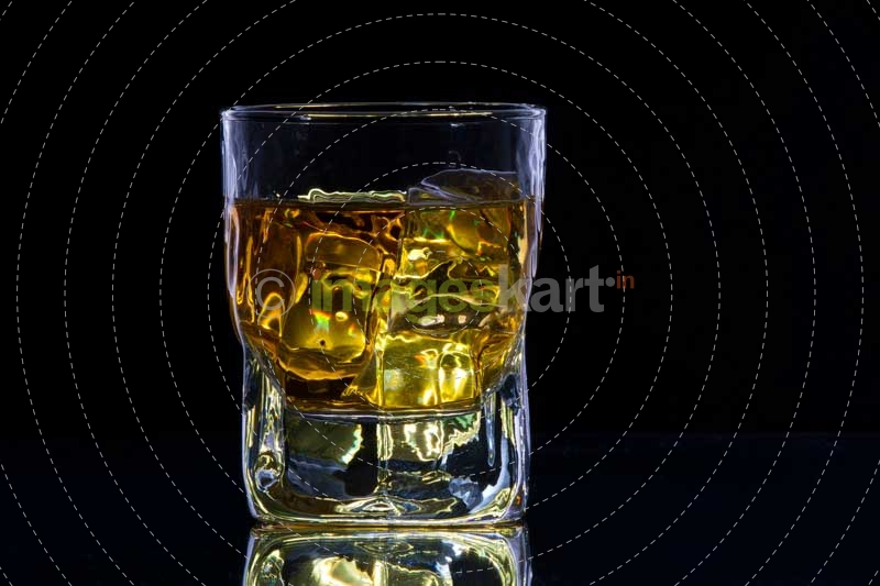 a glass of alcohol with ice cubes
