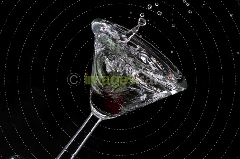close up of a cocktail drink with a cherry in motion