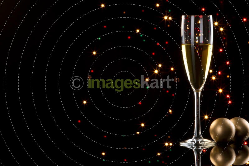 champagne glass with black background with decorative balls