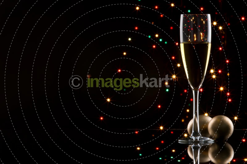 champagne glass with black background with decorative balls