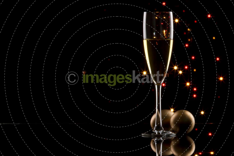 champagne glass with black background and decorative balls