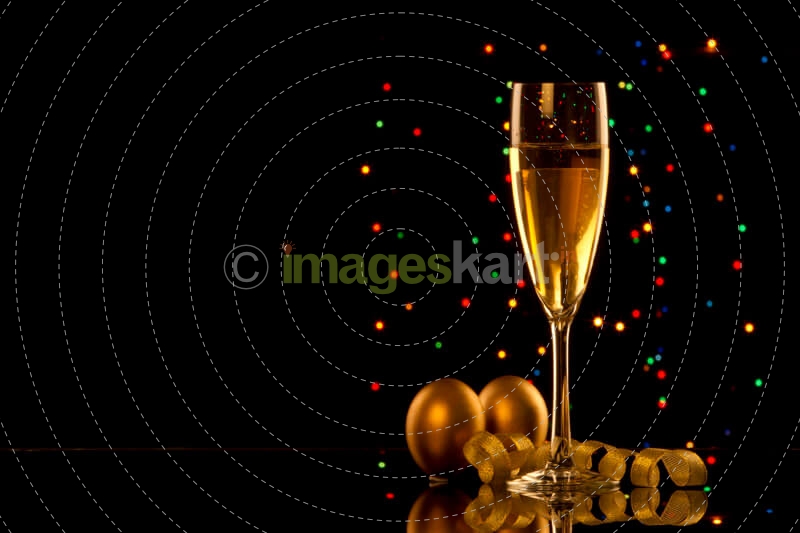 champagne glass with black background and decorative balls