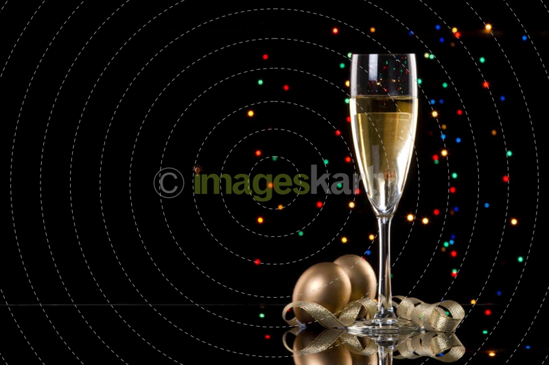 champagne glass with black background and decorative balls