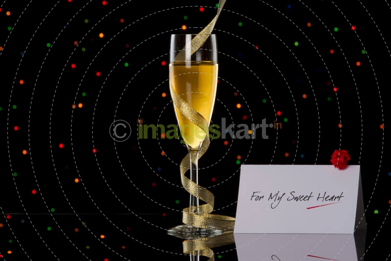 champagne glass with black background and note