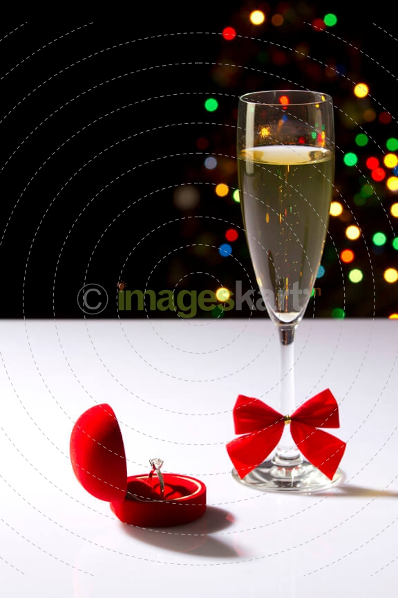 close upshot of wine glass and wedding ring with lights in the dark b