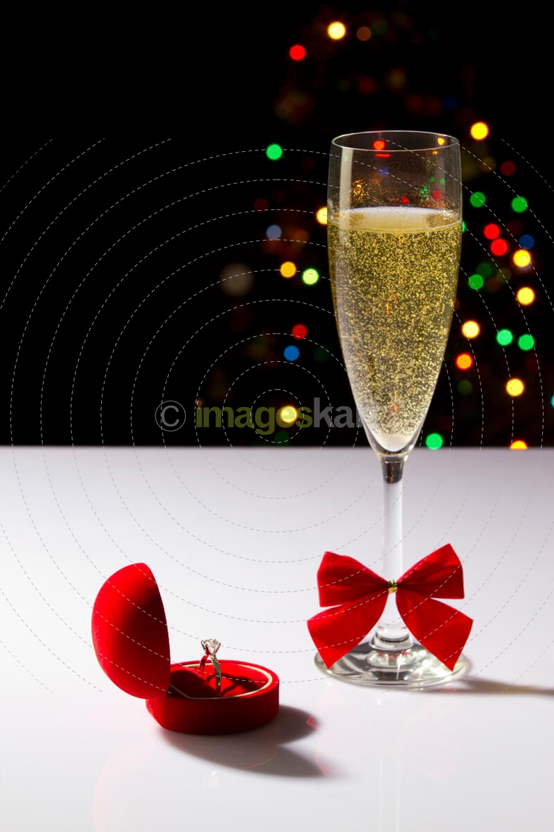 a flute glass full of champagne fizz with lights in the background