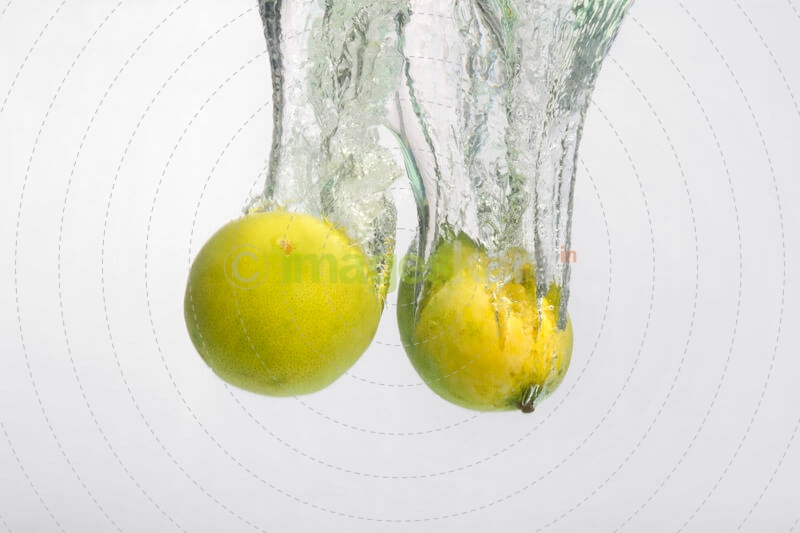 yellow coloured fruits falling into the water