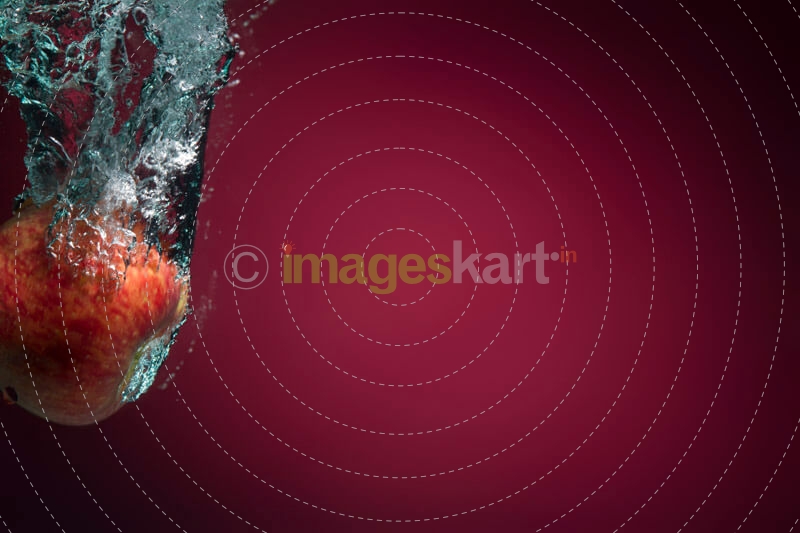 apple in water against maroon background 