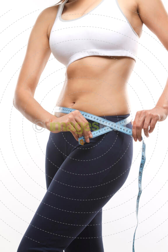 slim girl measuring waist with tape