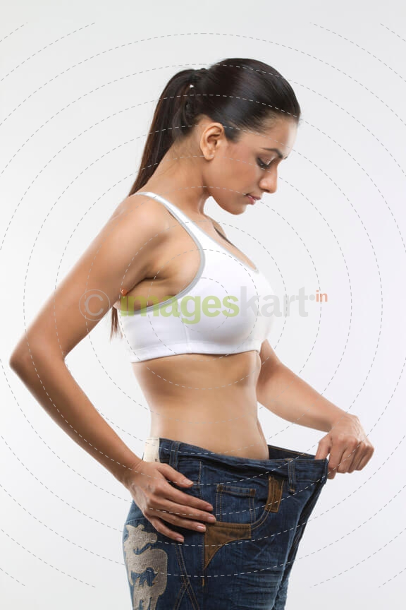 young woman stretching her loose jeans
