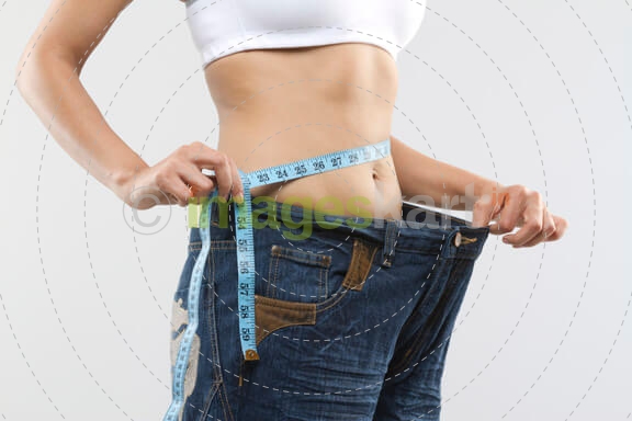 woman measuring her waistline