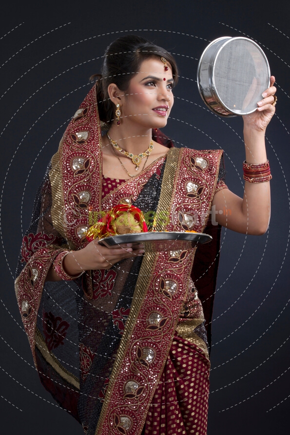 Indian woman looking at the strainer on karva chauth