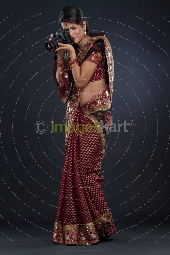 woman in an indian saree taking a picture