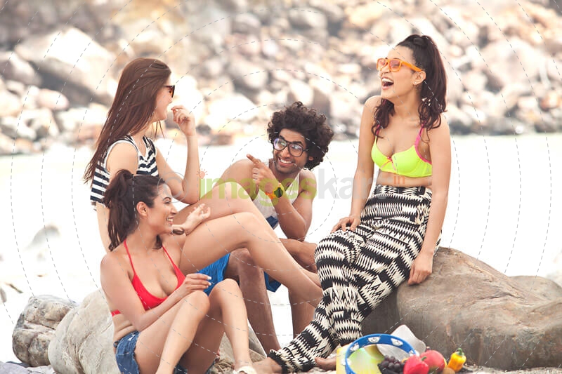group of friends sitting along the shore laughing