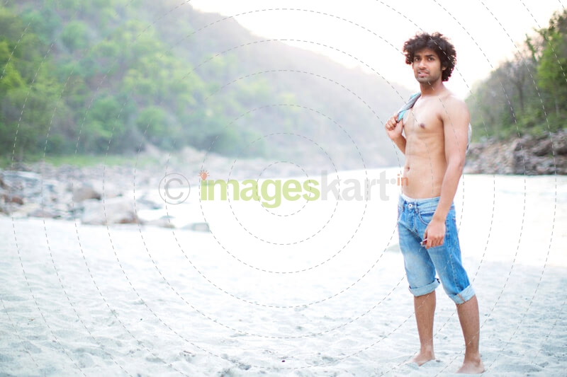 a man posing shirtless while carrying his shirt