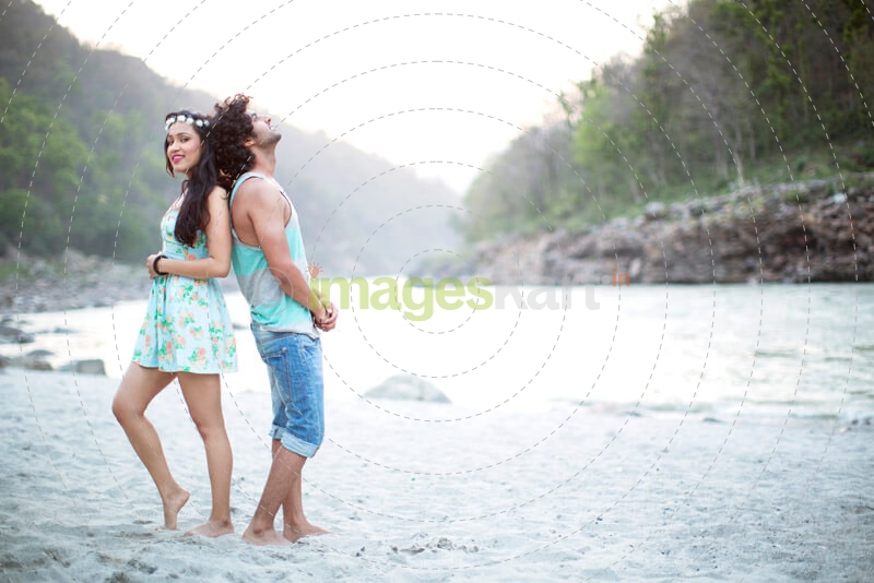 young couple romancing by the riverside 