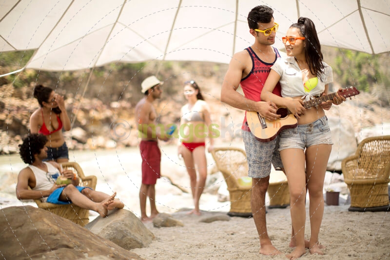  teenage boy making a girl learn to play guitar