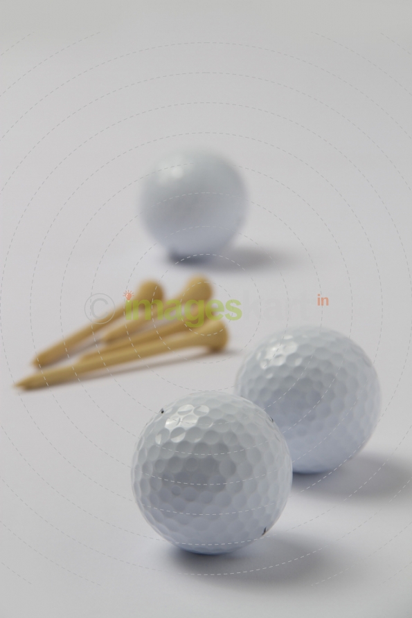 close up shot of golf balls and ball pins 