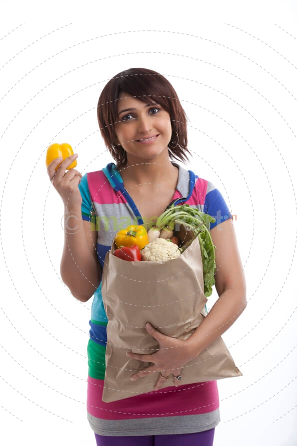 woman smiling with a bag full of vegetables 