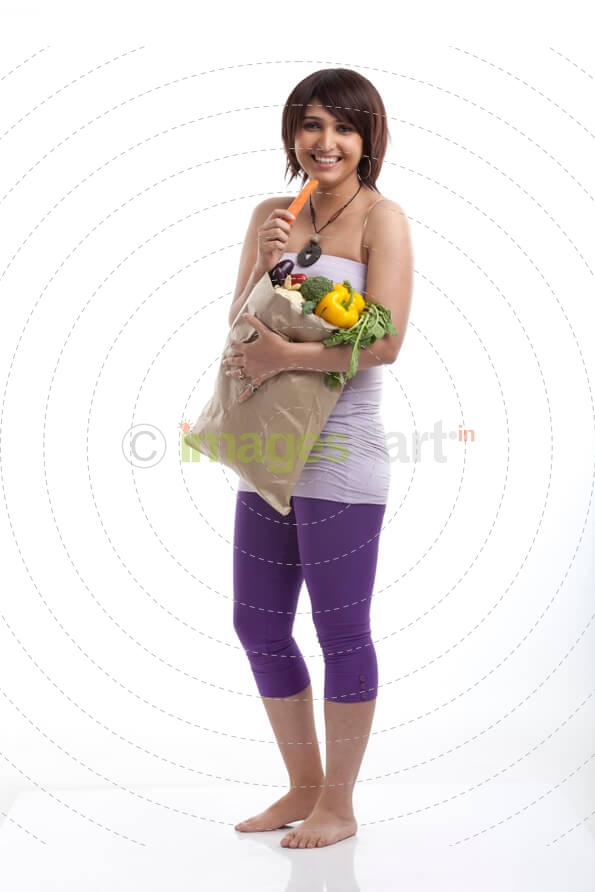 young woman eating a carrot from her basket