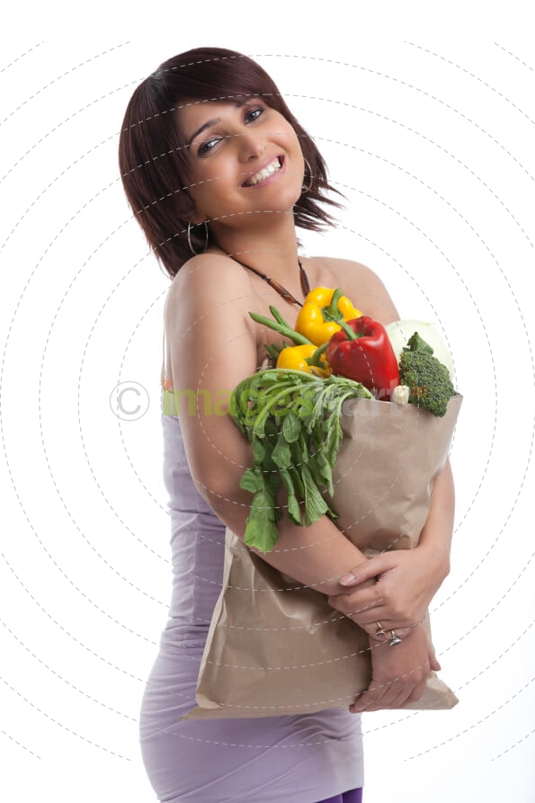 woman with short hair holding vegetables