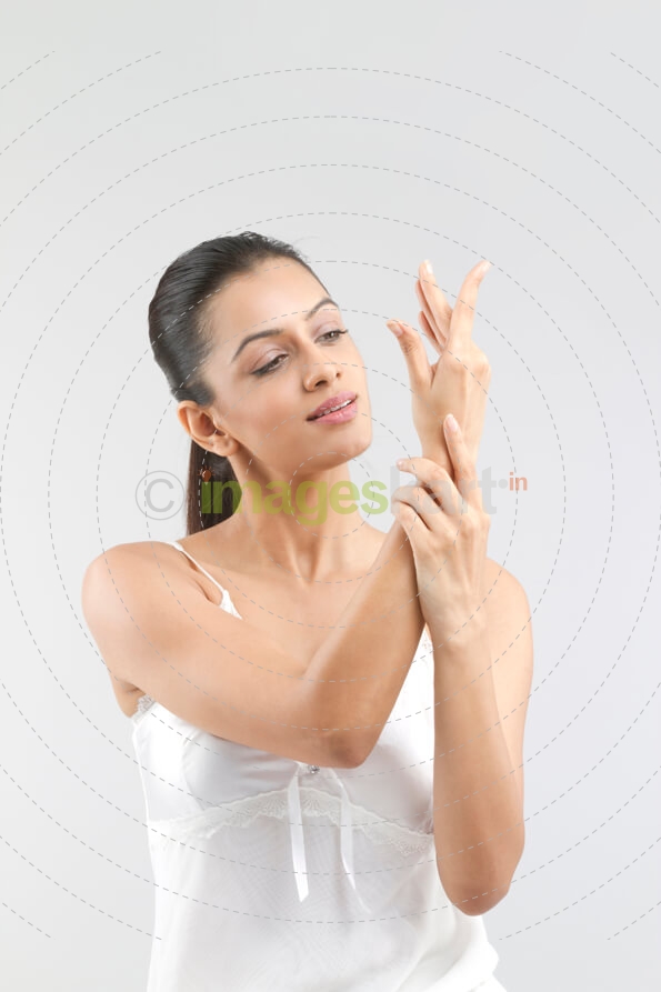 portrait of an attractive female applying a skin product