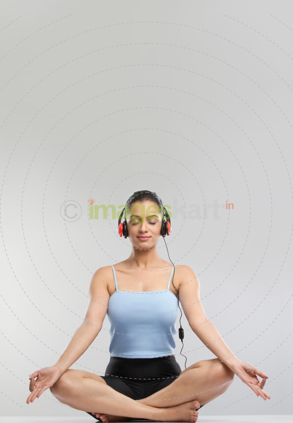 young girl performing meditation with headphone on 