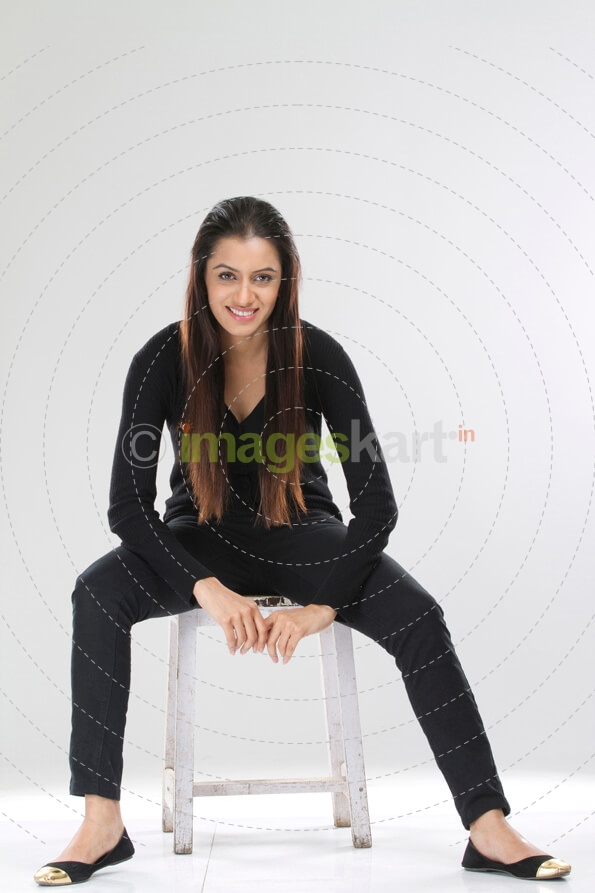 pretty girl sitting on a stool against white background