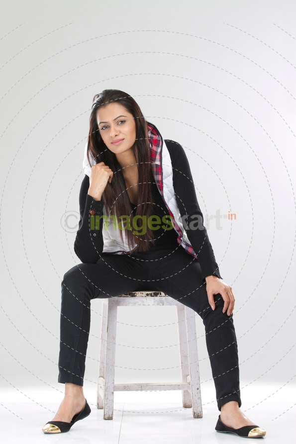 portrait of a smiling lady sitting on a stool in a hoodie