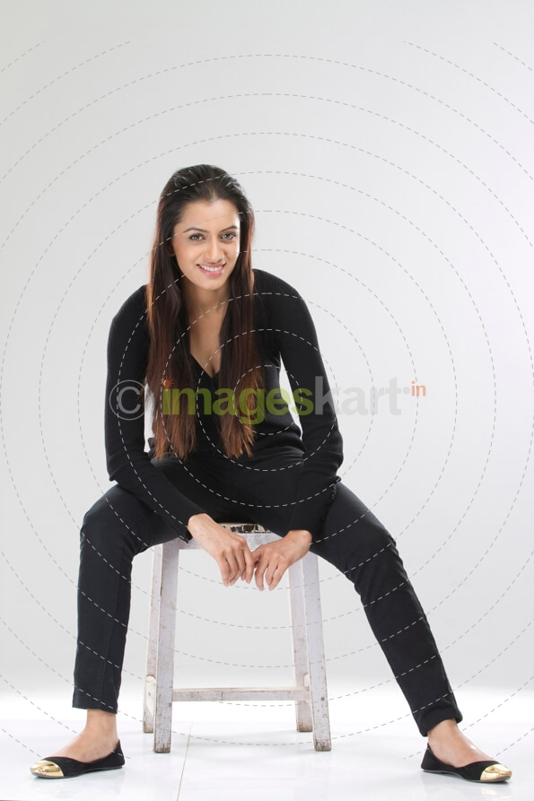 portrait of a stylish girl sitting on a stool against white background