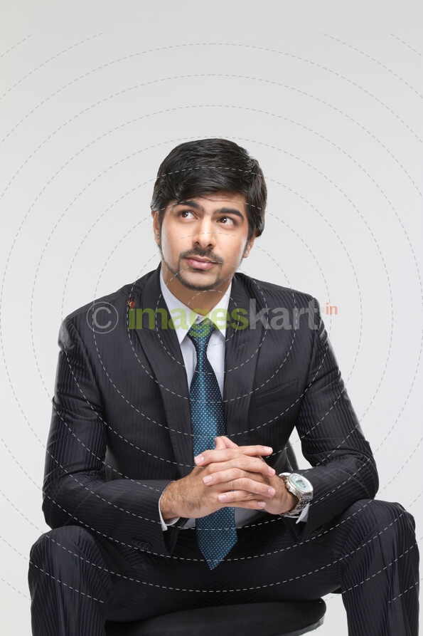 young male executive sitting on a chair and posing 