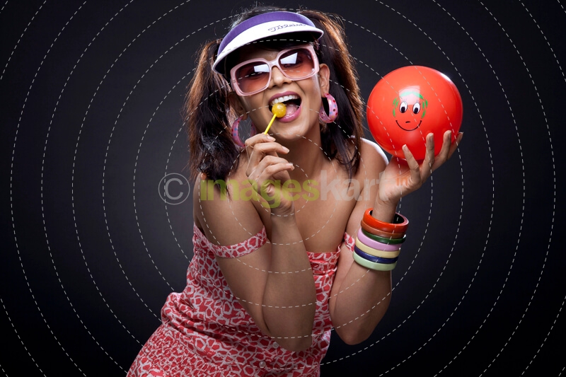 trendy model posing with red ball and lollipop