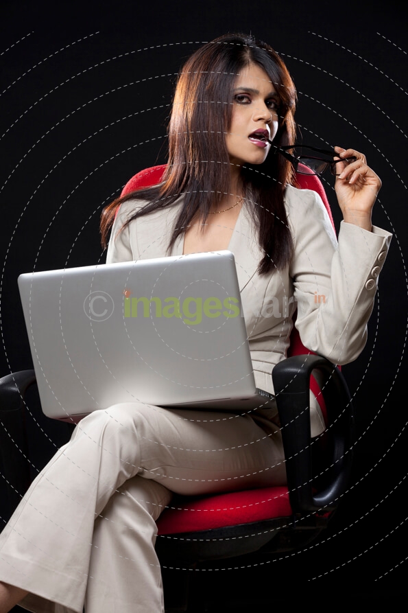 glamorous corporate woman posing while sitting in a chair