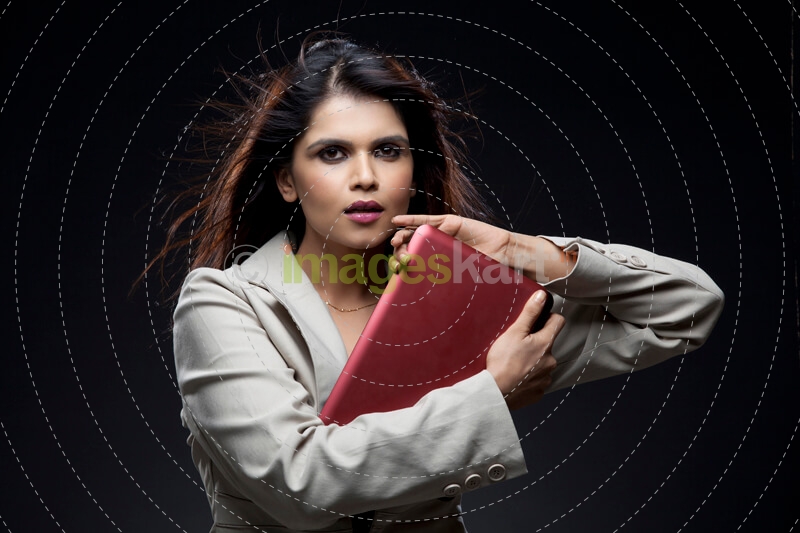 businesswoman holding a laptop close to her chest