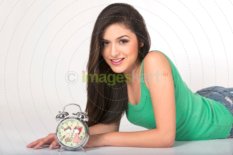 a young girl posing with a alarm clock