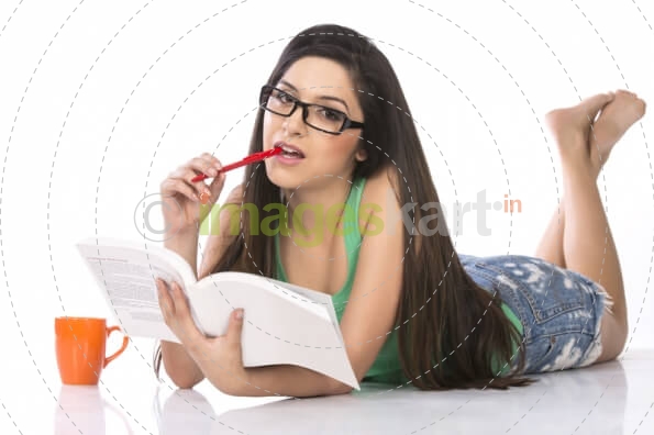 girl wearing specs and posing with a book against a white background