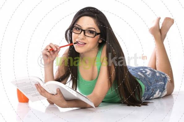 front view of a young teenage girl holding a pencil and a book