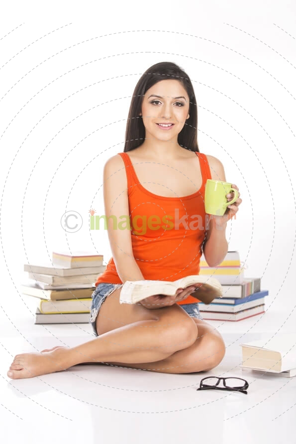 young female holding a coffee mug and a novel