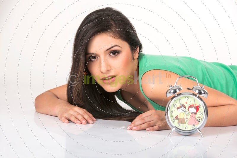 girl lying on floor while posing with clock