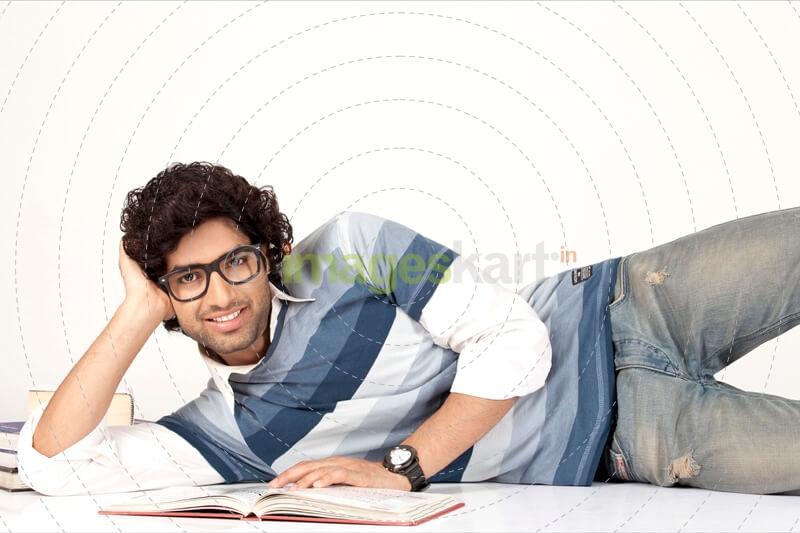 college boy reading book while posing for the camera 