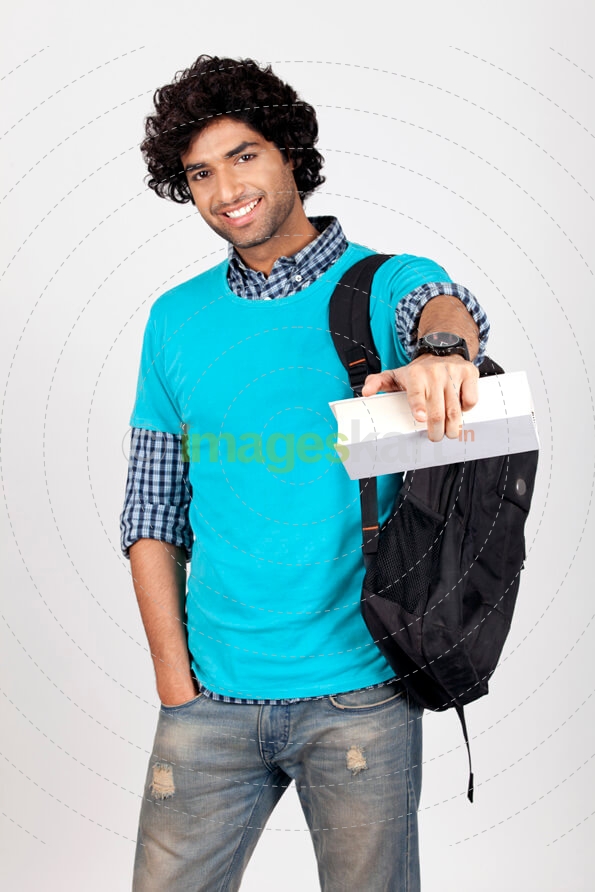 college boy with book pointing at camera 