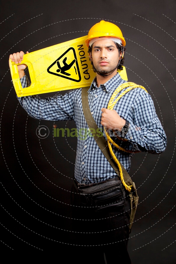 man carrying  caution stand looking at the camera 