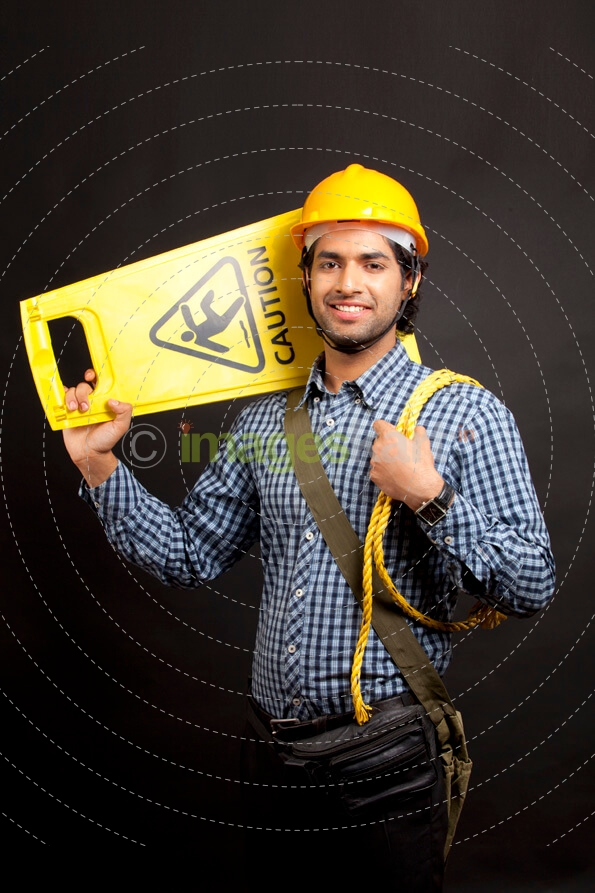 man carrying  caution stand and posing while looking at the camera