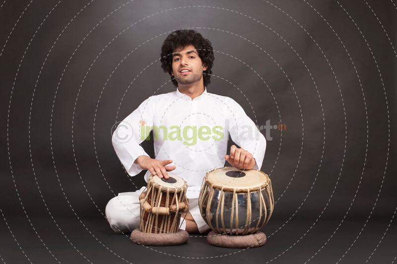 man performing classical music with tabla  