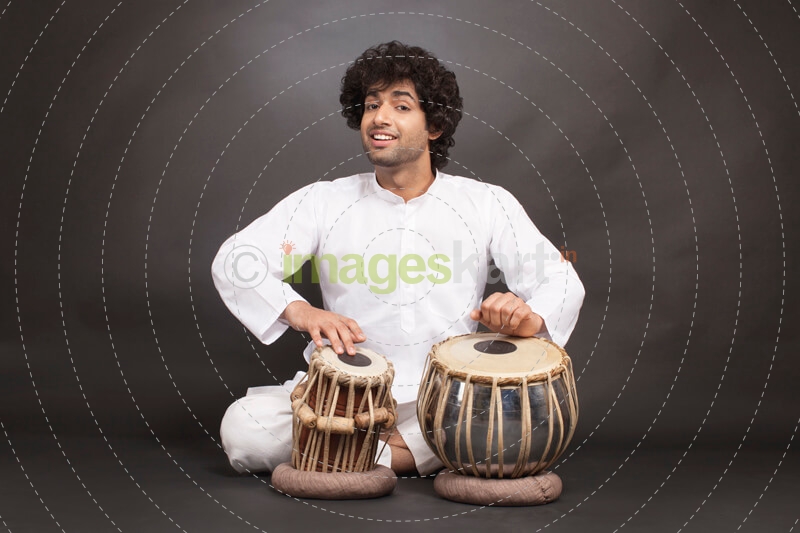 man playing tabla while looking at the camera 